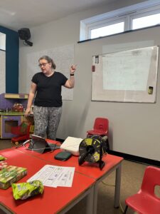 Lydia Lings stands in front of a whiteboard, explaining how to use Makaton